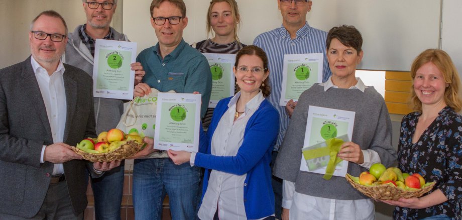 Strahlende Gesichter bei der Präsentation der Wettbewerbsergebnisse: Bei den Siegern stehen Oberbürgermeister Ralf Claus (ganz links), Claudia Lill von der Energieagentur Rheinland-Pfalz (Mitte vorn) sowie die Klimaschutzmanager Georg Leufen-Verkoyen (dritter von rechts) und Elisa Michel-Karacic, Klimaschutzmanagerin (ganz rechts). Bild: Stadt Ingelheim