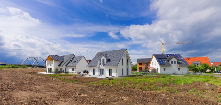 Neu gebaute Einfamilienhäuser vor blauem Himmel