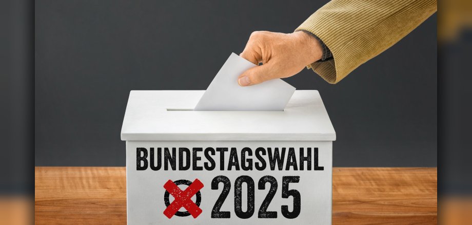 Mann wirft einen Stimmzettel in Wahlurne - Bundestagswahl 2025