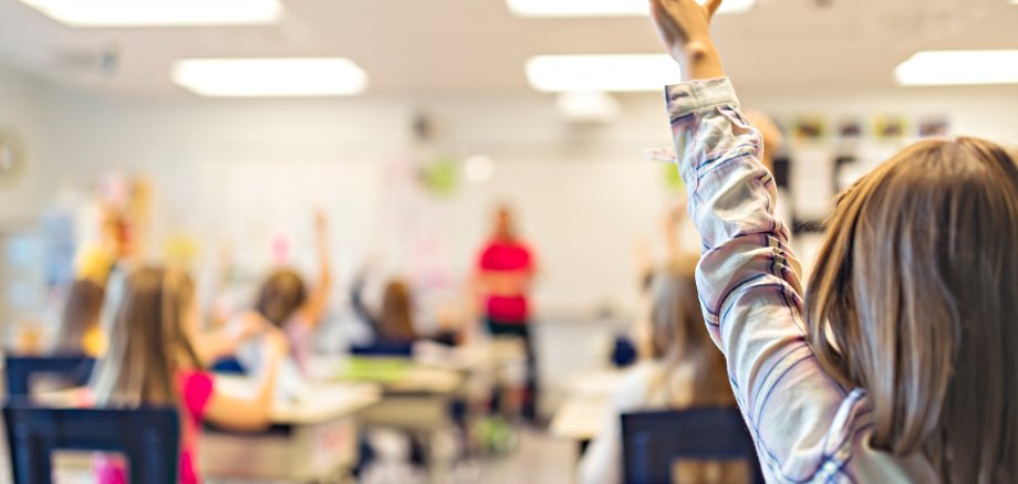 Kinder melden sich im Schulunterricht